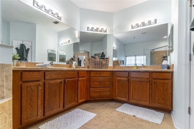 bathroom featuring tile patterned flooring, vanity, and a shower with door