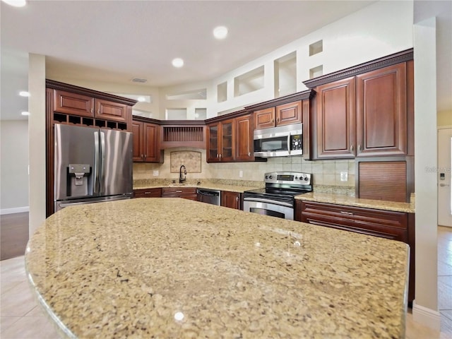 kitchen featuring sink, light tile patterned floors, appliances with stainless steel finishes, light stone countertops, and backsplash