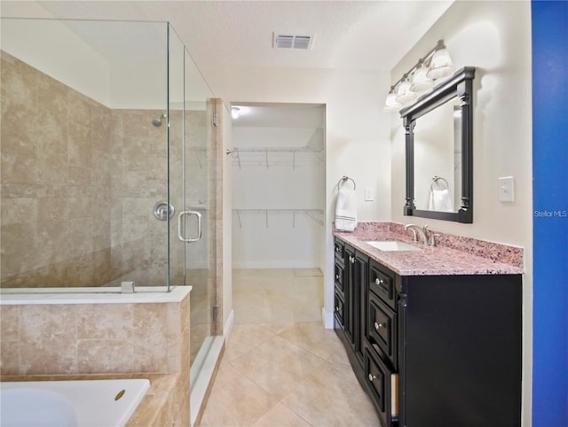 bathroom with tile patterned floors, vanity, separate shower and tub, and a textured ceiling