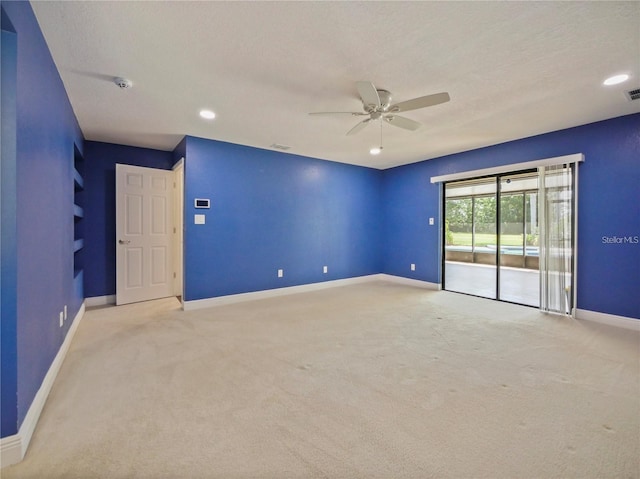 carpeted empty room featuring ceiling fan and a textured ceiling