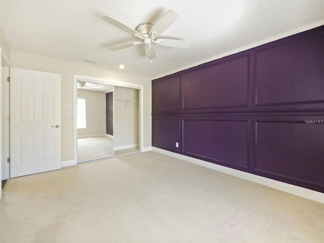 unfurnished bedroom with ceiling fan, light colored carpet, and a closet