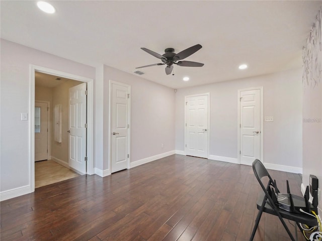 interior space with ceiling fan and dark hardwood / wood-style flooring