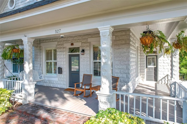 view of exterior entry featuring covered porch