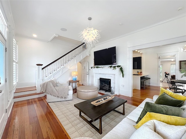 living room featuring ornamental molding, a chandelier, and light hardwood / wood-style floors