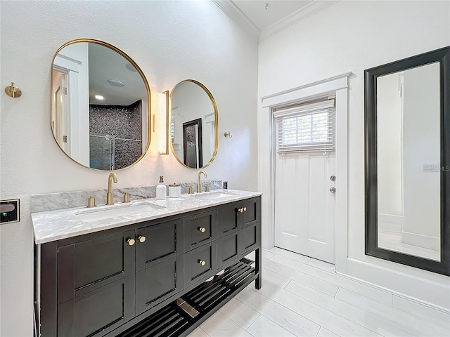 bathroom with ornamental molding, vanity, and walk in shower