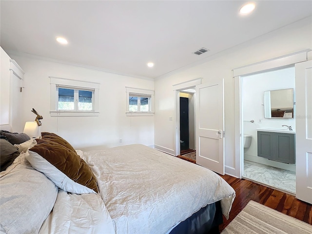 bedroom featuring ensuite bath, ornamental molding, dark hardwood / wood-style floors, and sink