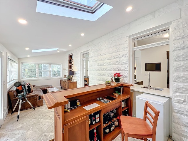 bar with lofted ceiling with skylight and sink