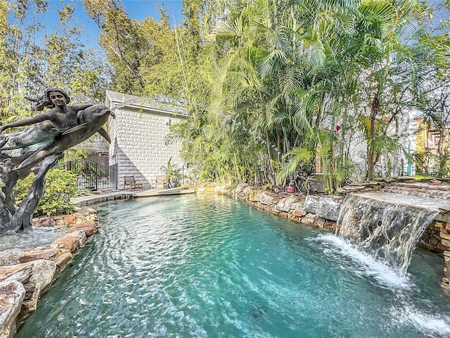 view of swimming pool with pool water feature