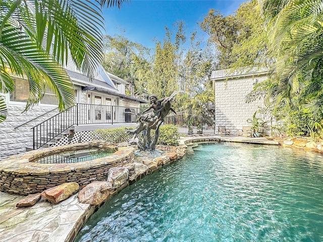 view of pool with an in ground hot tub and a deck