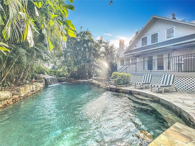 view of swimming pool with a patio and pool water feature