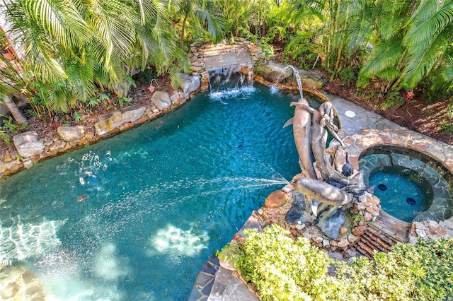 view of pool featuring a garden pond and an in ground hot tub