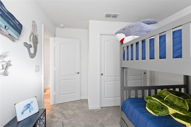 carpeted bedroom featuring a closet and a textured ceiling