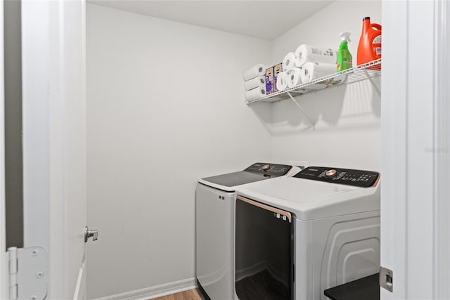 washroom featuring hardwood / wood-style flooring and washing machine and dryer