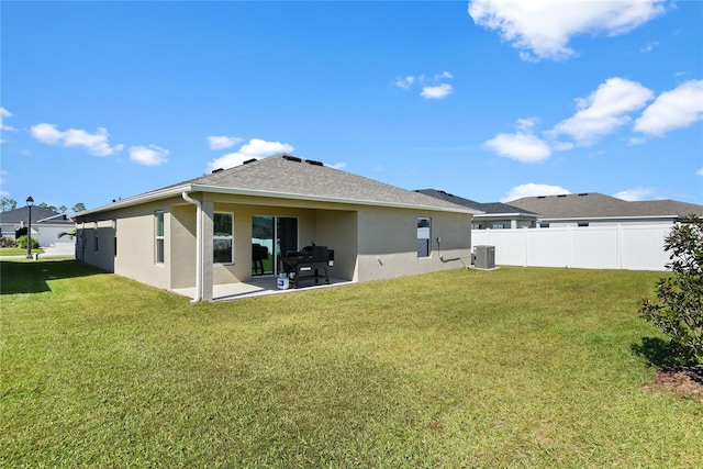 rear view of house with a patio, a lawn, and central air condition unit