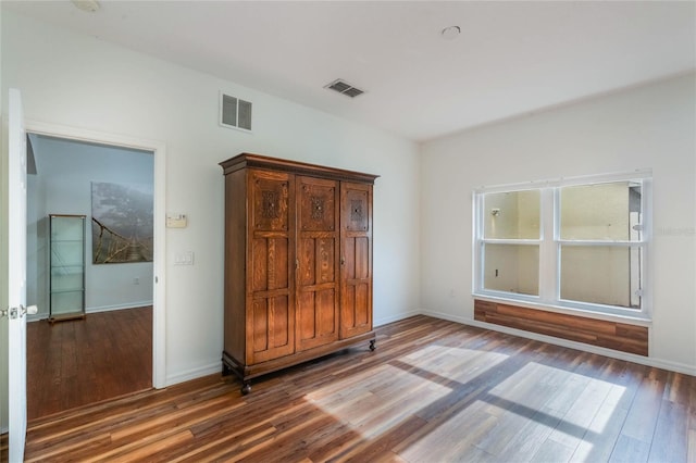 unfurnished bedroom with dark wood-type flooring