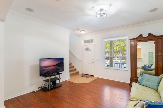 living room with hardwood / wood-style flooring, ornamental molding, and a textured ceiling