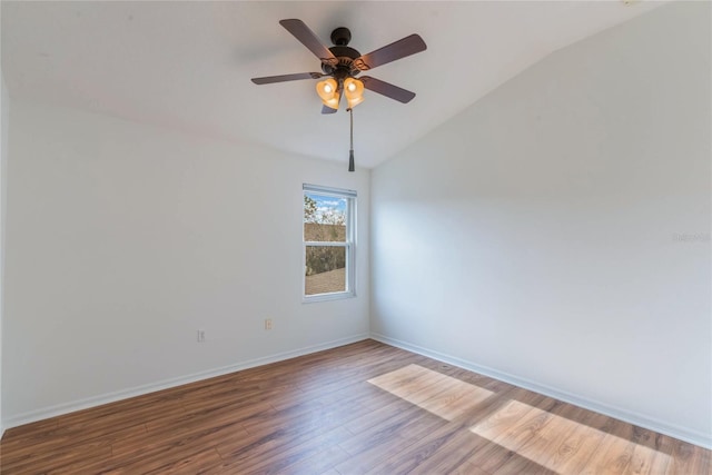 empty room featuring hardwood / wood-style flooring, ceiling fan, and vaulted ceiling