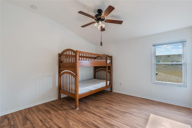 unfurnished bedroom with wood-type flooring, lofted ceiling, and ceiling fan