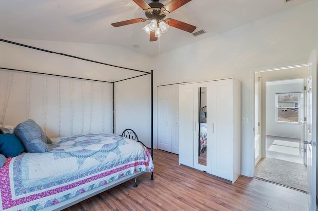 bedroom with light hardwood / wood-style flooring, vaulted ceiling, a closet, and ceiling fan