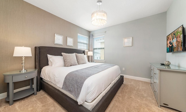 bedroom featuring light carpet and an inviting chandelier