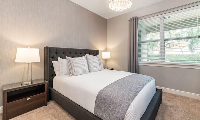 carpeted bedroom with a notable chandelier