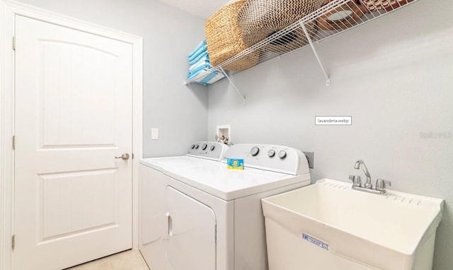 laundry area featuring sink, light tile patterned floors, and washer and dryer