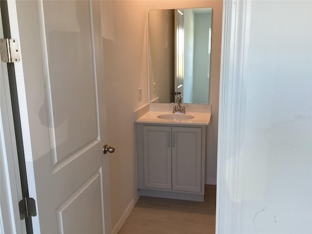 bathroom with tile patterned flooring, baseboards, and vanity