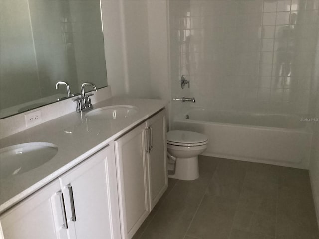 bathroom featuring tile patterned floors, a sink, toilet, and double vanity