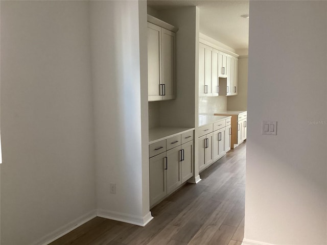 hallway featuring baseboards and wood finished floors