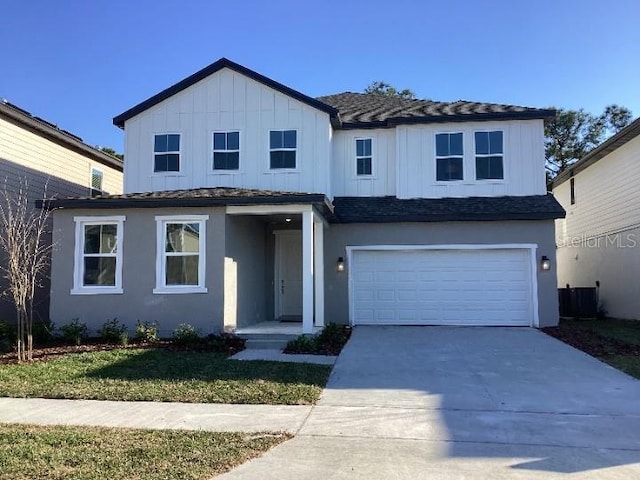 traditional-style home with board and batten siding, concrete driveway, an attached garage, and stucco siding