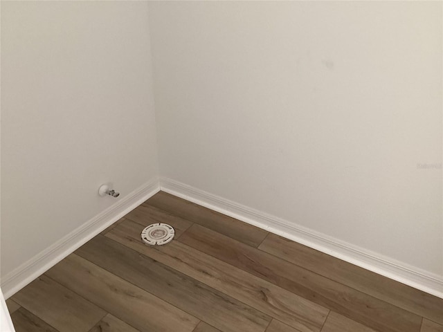 laundry area with baseboards and dark wood finished floors