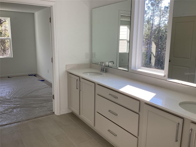 bathroom featuring tile patterned flooring, a sink, and double vanity