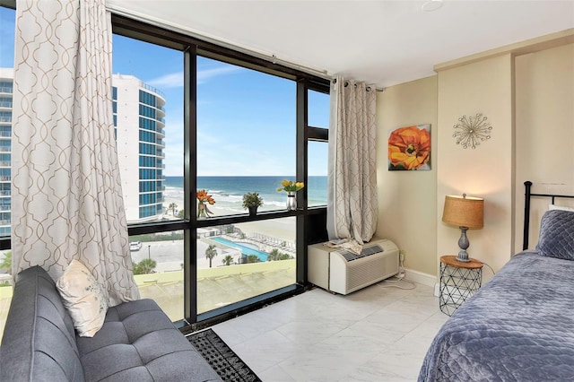 bedroom featuring a water view, an AC wall unit, and a wall of windows