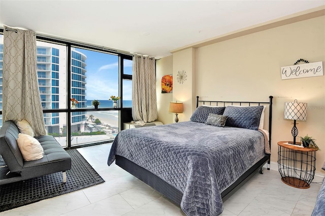 bedroom featuring a water view and floor to ceiling windows