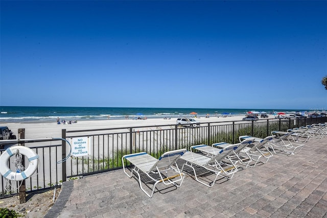 view of patio with a beach view and a water view