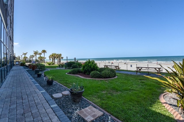 view of yard with a water view and a view of the beach