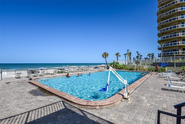 view of pool with a water view and a patio area