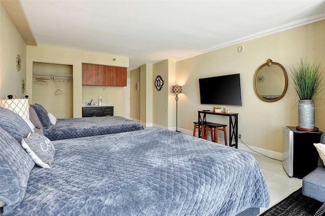 bedroom featuring ornamental molding, bar, a closet, and light tile patterned floors