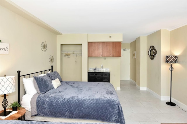 tiled bedroom with a closet and bar area