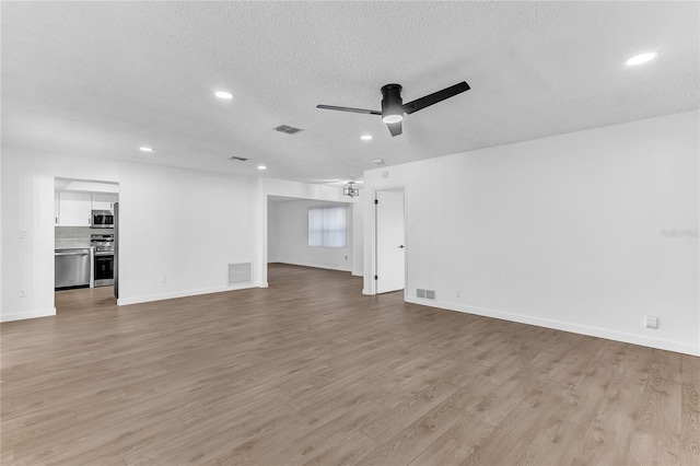 unfurnished living room with ceiling fan, light hardwood / wood-style flooring, and a textured ceiling