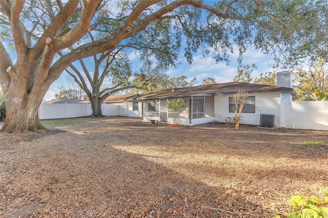 rear view of property with cooling unit and a sunroom