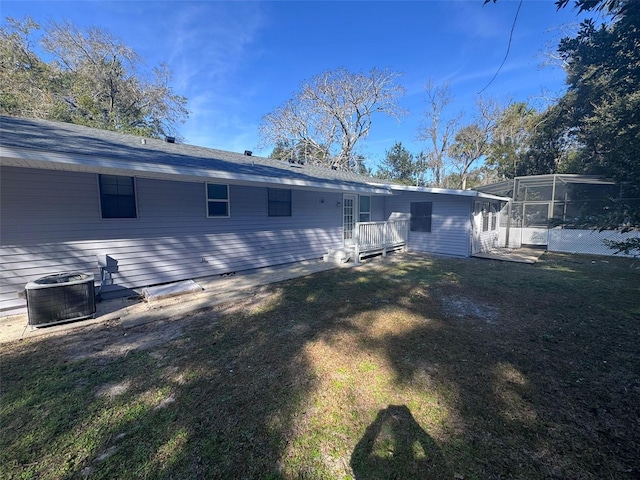 back of house featuring central AC unit and a yard