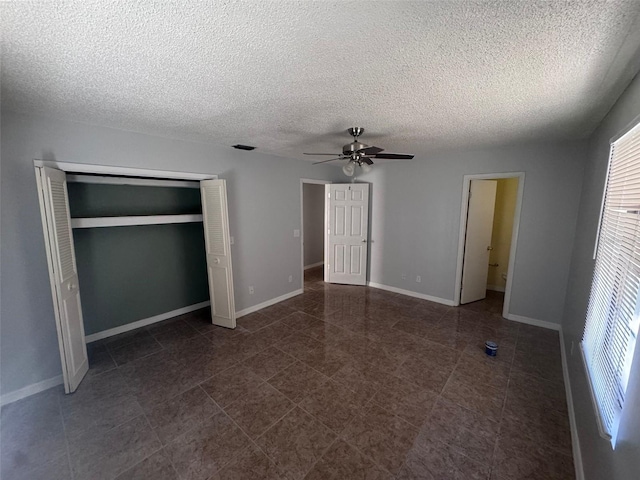 unfurnished bedroom with a textured ceiling, a closet, and ceiling fan