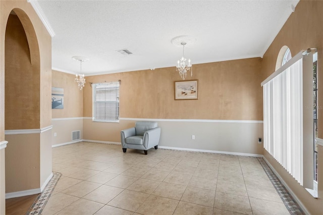 living area with a textured ceiling, a chandelier, and light tile patterned flooring