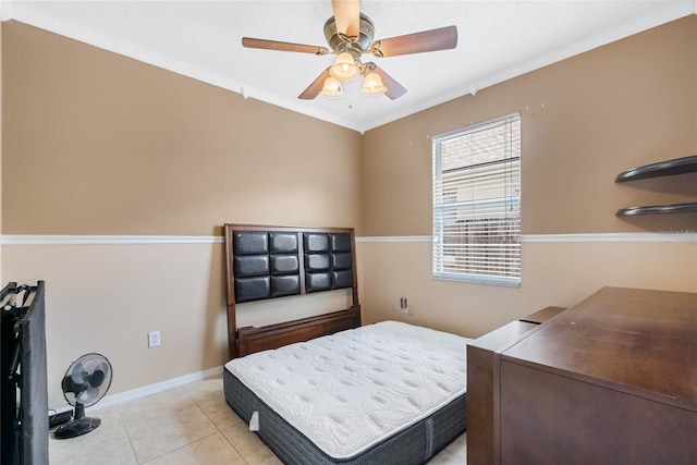 bedroom featuring light tile patterned flooring, ornamental molding, and ceiling fan