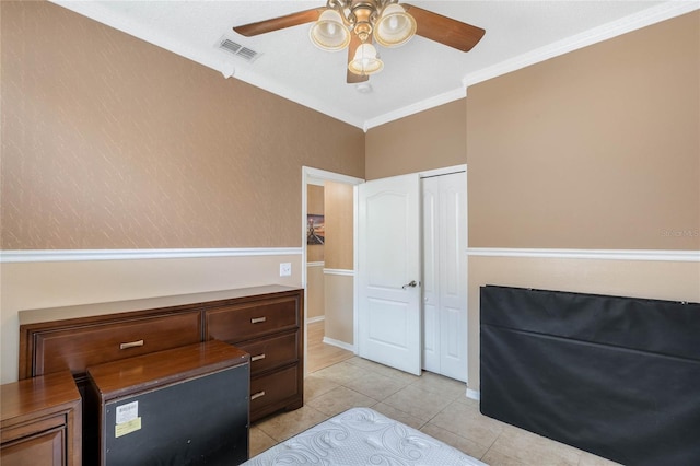 tiled bedroom with crown molding, a closet, and ceiling fan