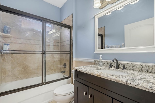 full bathroom featuring vanity, enclosed tub / shower combo, and toilet