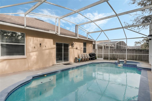 view of pool featuring an in ground hot tub, a patio area, and glass enclosure