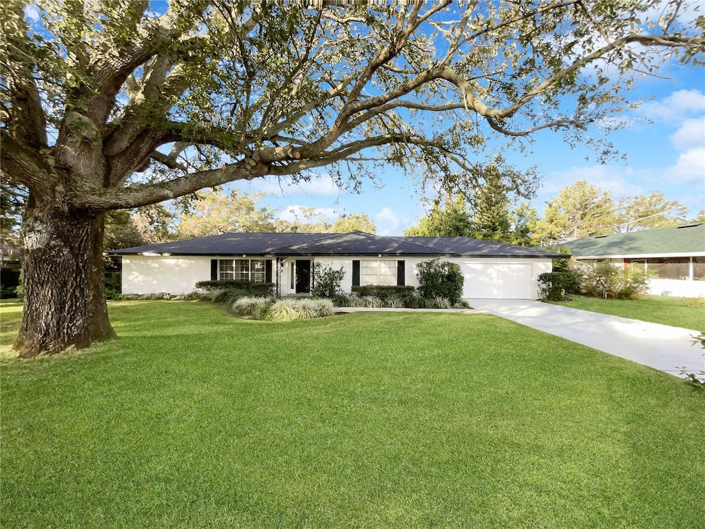 single story home with a garage and a front yard