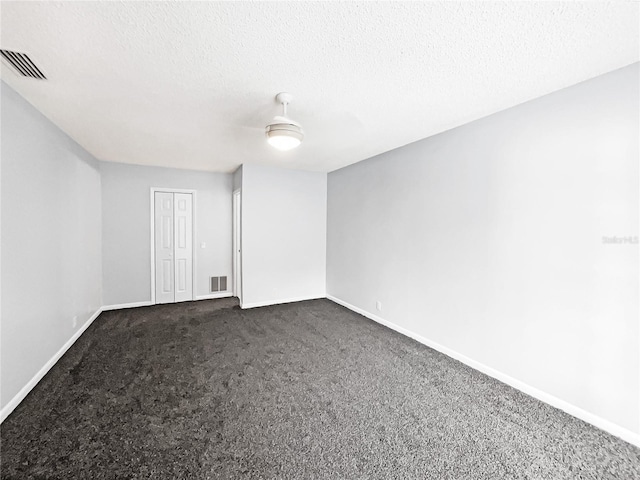 carpeted empty room featuring a textured ceiling